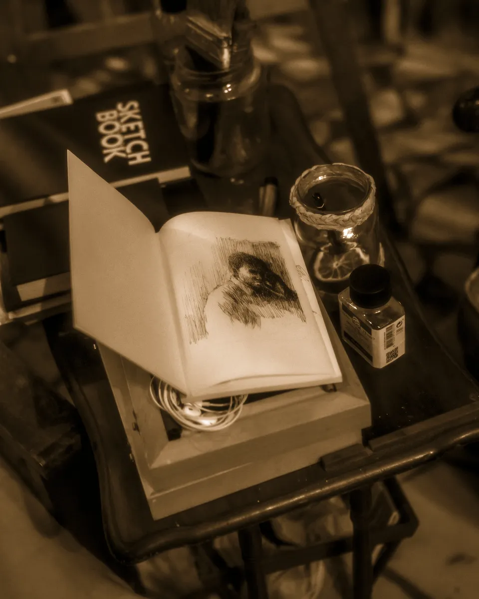Un carnet de croquis ouvert sur un établi d'atelier.